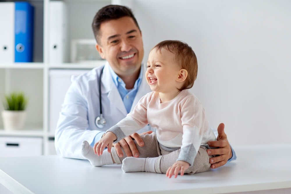 Médecin souriant avec bébé souriant